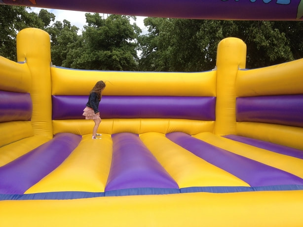 young girl jumping by herself in a bouncy castle 