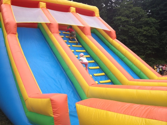 two children racing to top of double slide bouncy castle 