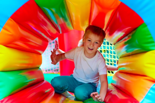 Young boy exiting a colourful blow up obstacle course